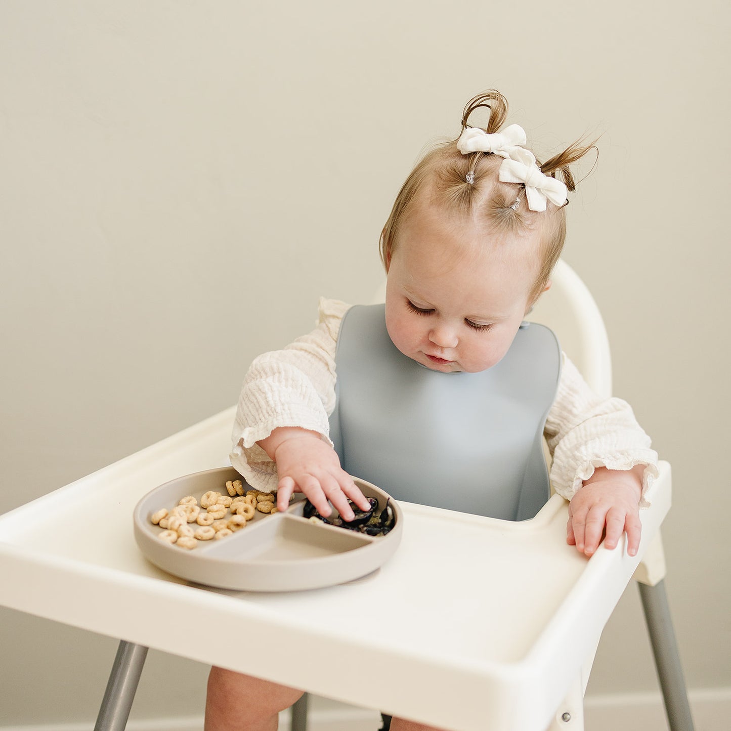baby using divided silicone suction plate and wearing a silicon bib