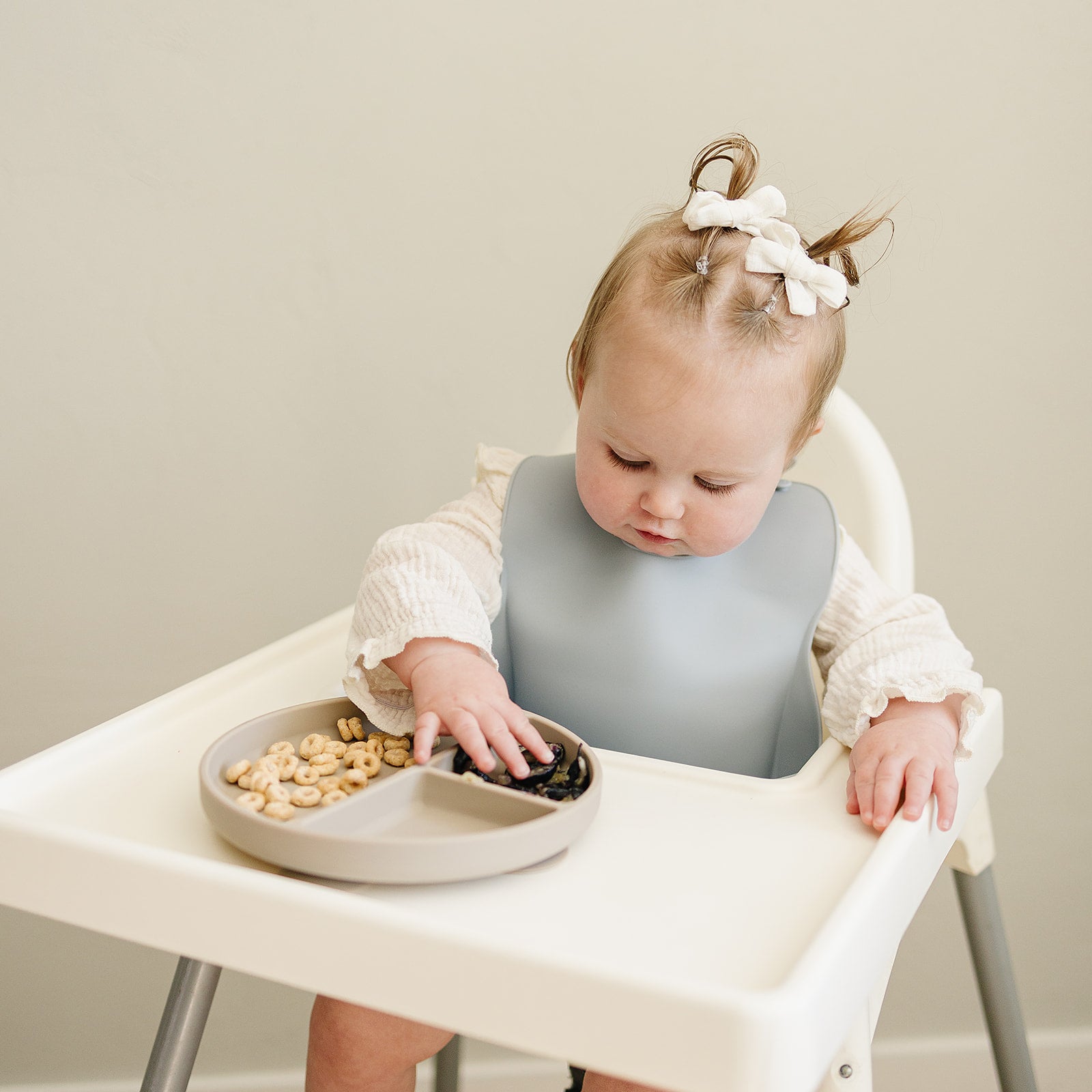 baby using divided silicone suction plate and wearing a silicon bib