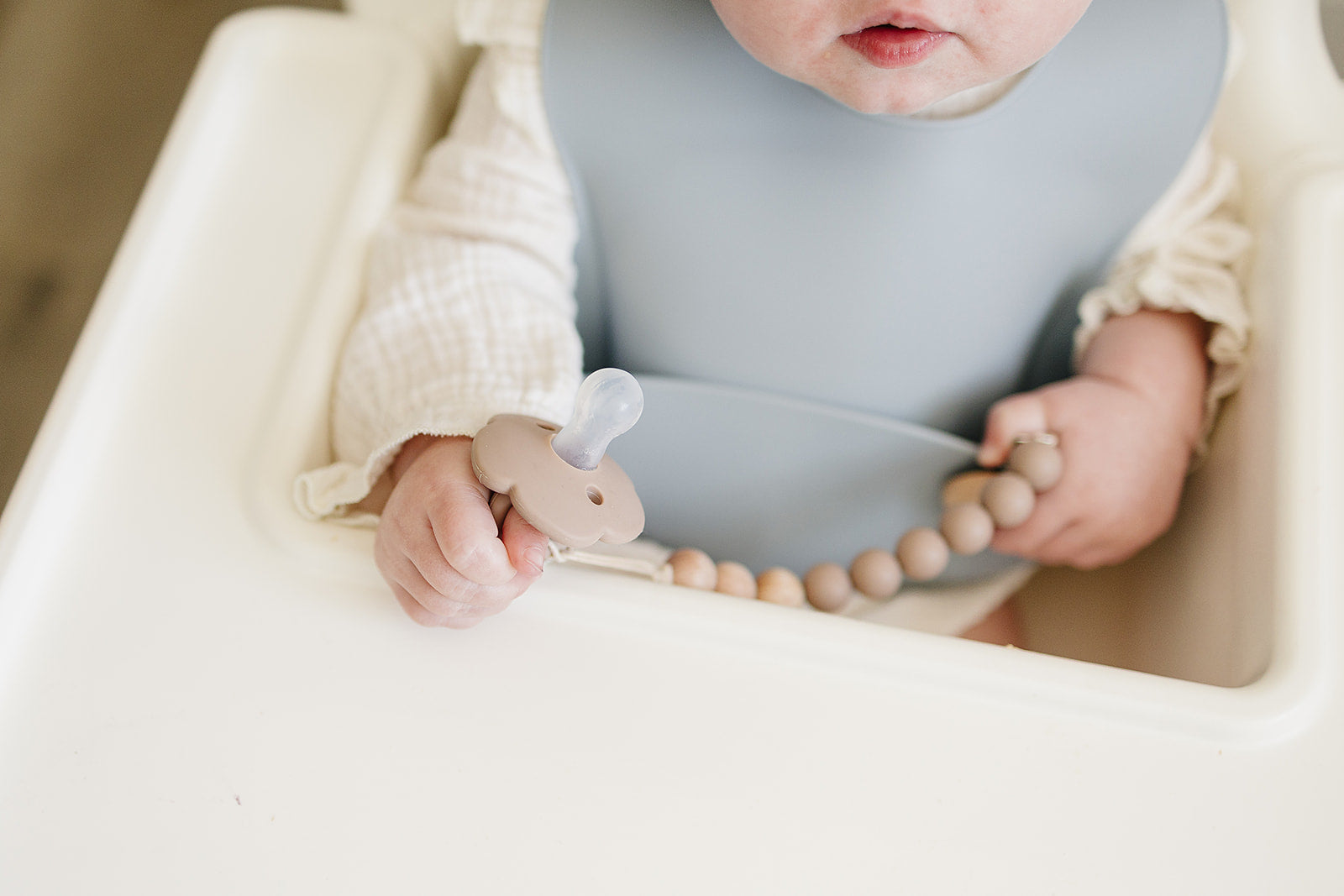 Ali + Tings pacifier clip attached to baby outfit