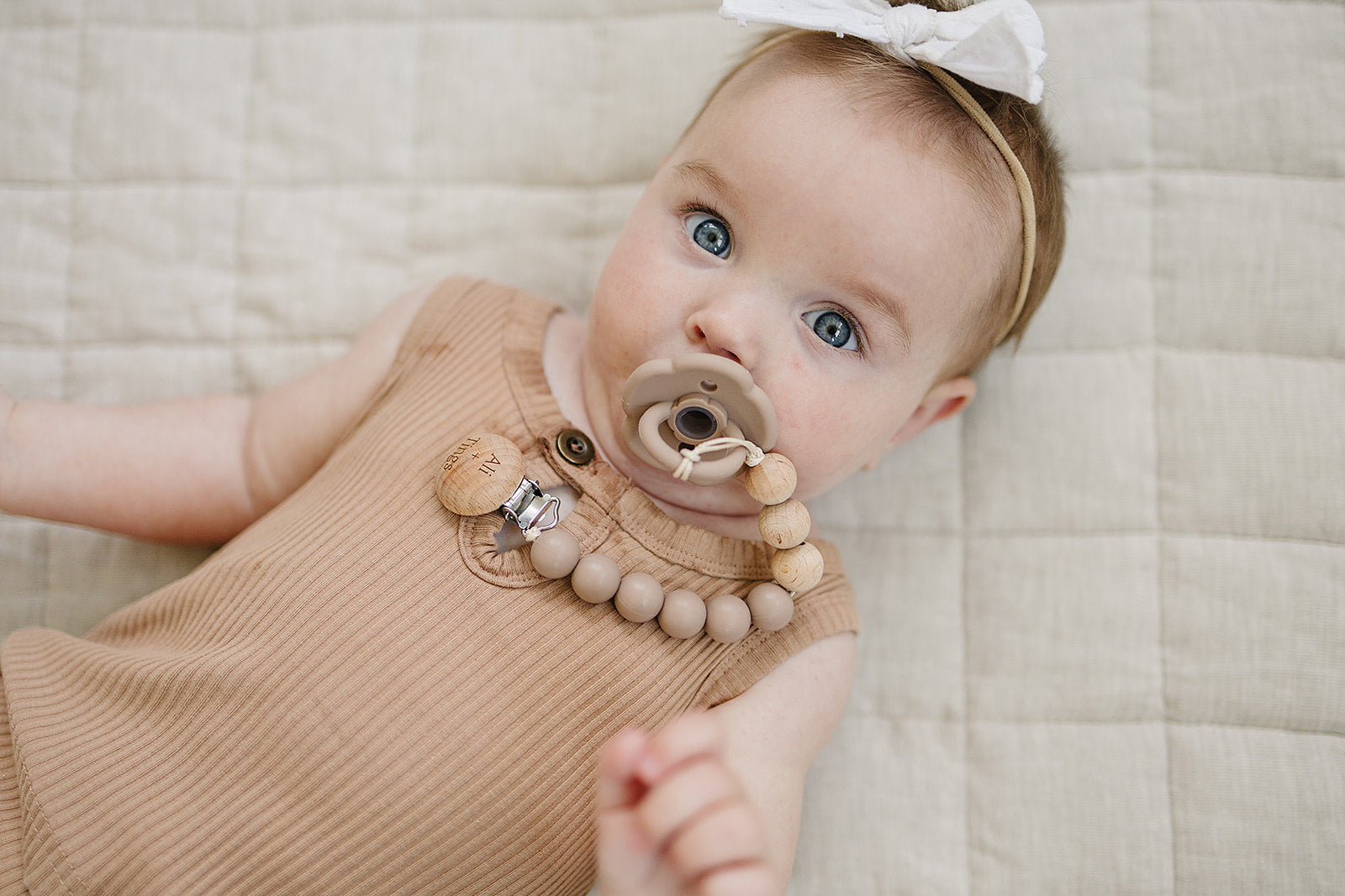 Ali + Tings pacifier clip attached to baby outfit