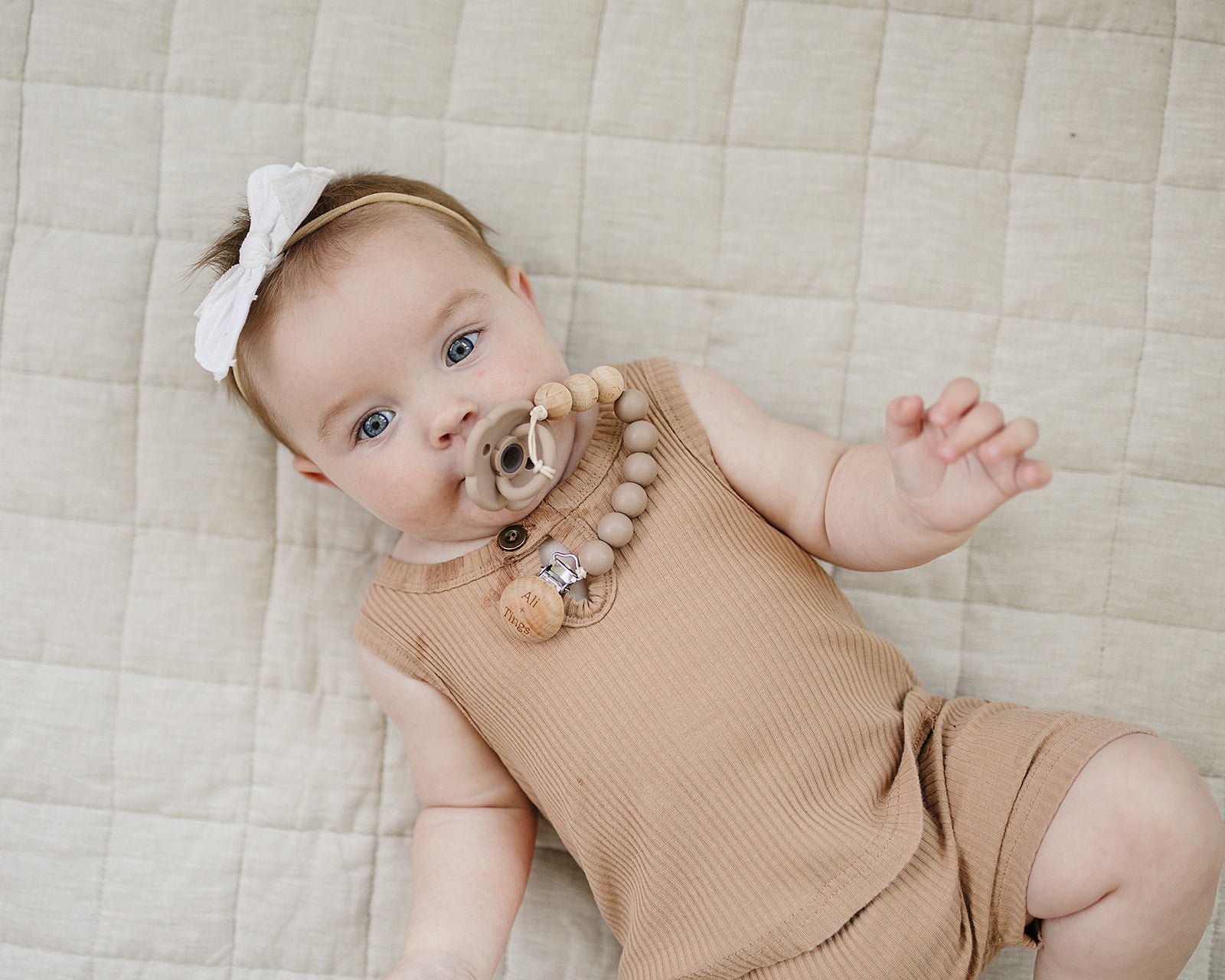 Ali + Tings pacifier clip attached to baby outfit